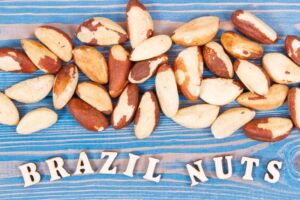 Lots of Brazil nuts raw over the words Brazil Nuts
