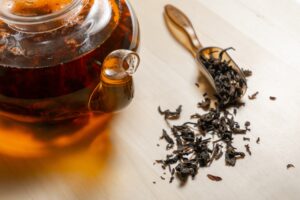 Loose leaf black tea with a teapot of tea