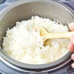 Best rice cookers with rice being cooked with wooden spoon in cooker