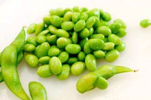 Costco edamame with shelled edamame beans next to pods
