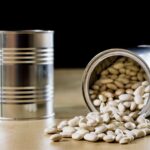 Canned white beans with beans coming out of a tin