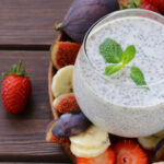 Chia seed pudding in a glass with fruit around it